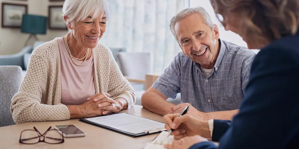 An older man and woman discussing their Medicare healthcare coverage with their Medicare 411 Translator - What Are the Differences Between Mediare Parts A and B?